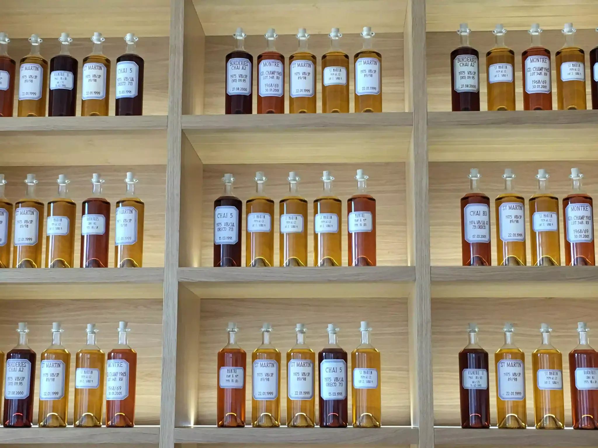 Bouteilles et verres de vin présentés dans un chai